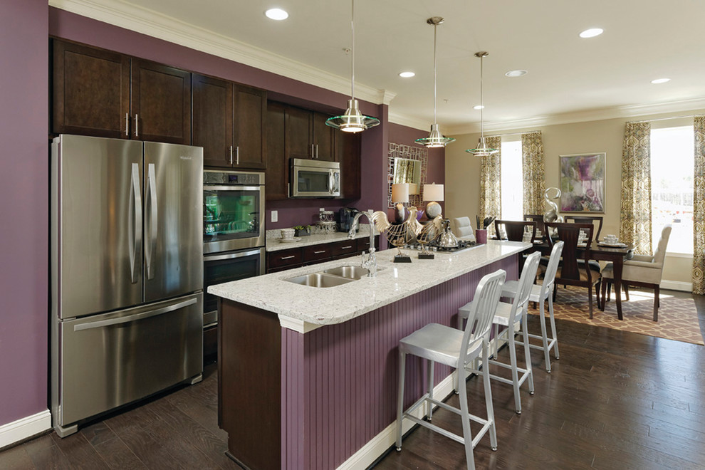 Eat-in kitchen - large transitional single-wall dark wood floor eat-in kitchen idea in Baltimore with an undermount sink, recessed-panel cabinets, dark wood cabinets, granite countertops, stainless steel appliances and an island