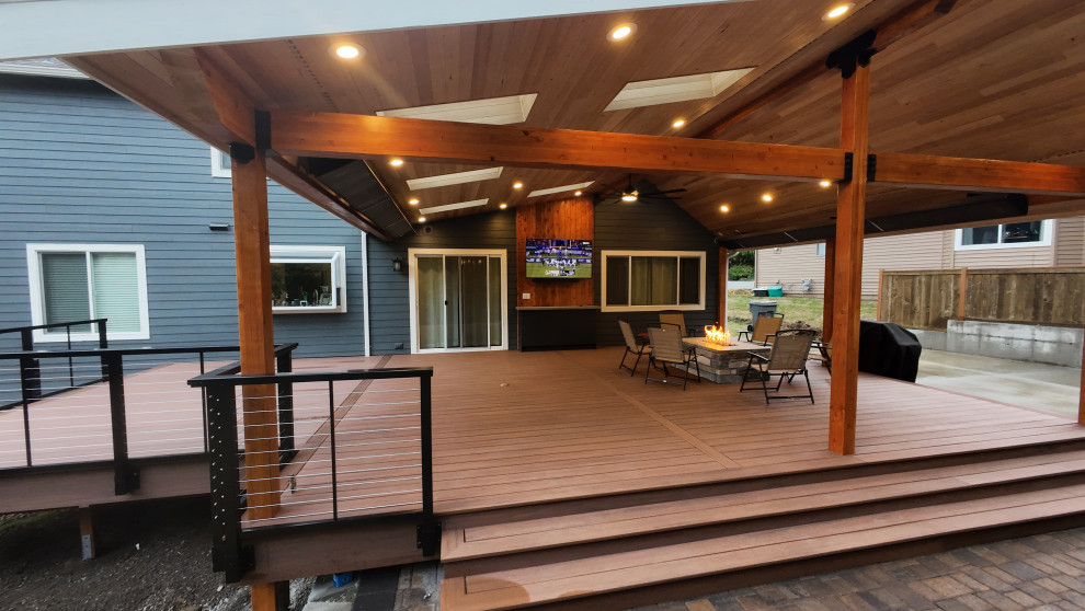 Inspiration for a large craftsman backyard ground level cable railing deck remodel in Seattle with a roof extension