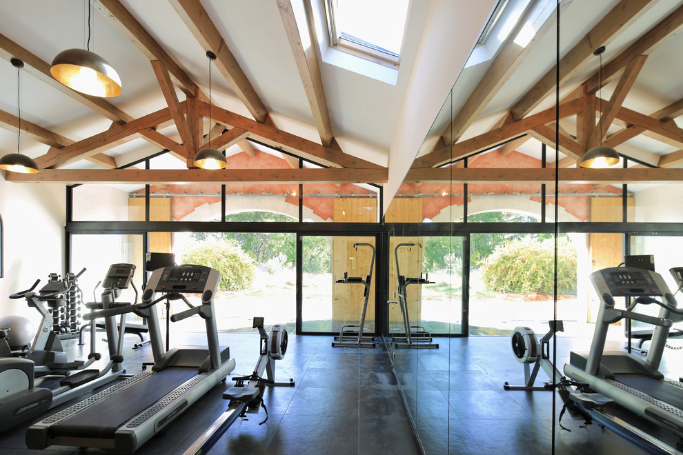 This is an example of a mid-sized country home weight room in Marseille with white walls.
