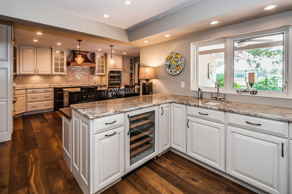 Inspiration for a timeless u-shaped open concept kitchen remodel in Tampa with an undermount sink, raised-panel cabinets, beige cabinets, granite countertops, white backsplash, subway tile backsplash and paneled appliances
