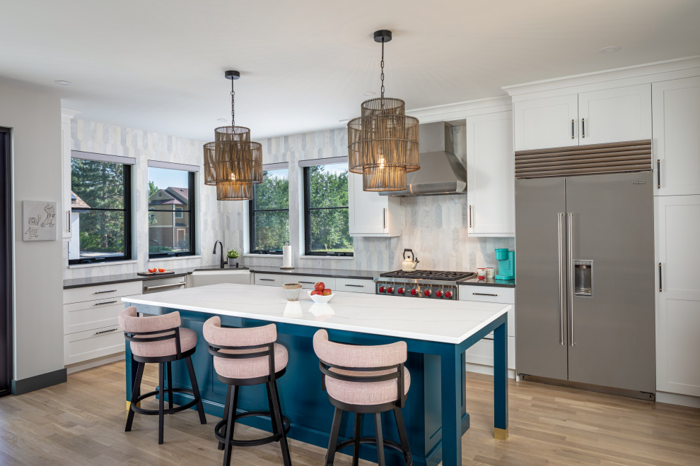 Inspiration for a transitional l-shaped light wood floor kitchen remodel in Denver with a farmhouse sink, shaker cabinets, white cabinets, quartz countertops, multicolored backsplash, marble backsplash, an island and gray countertops