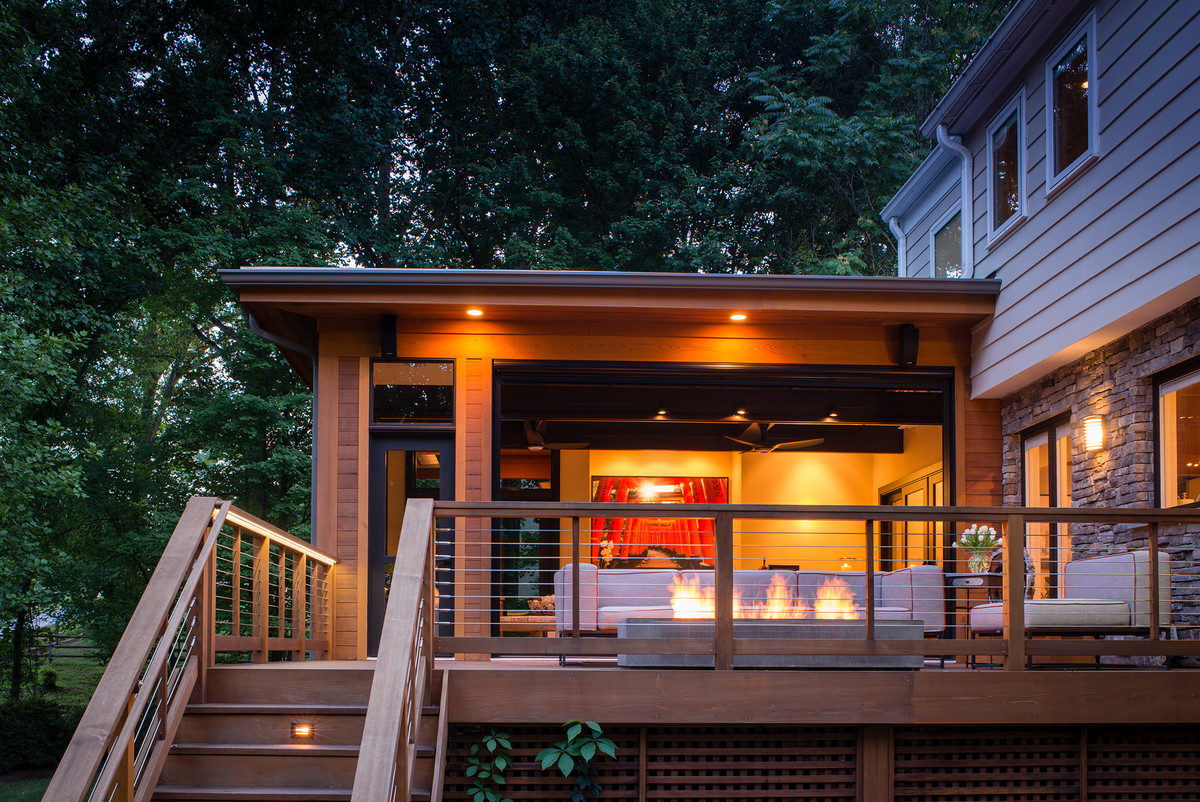 Mid-sized transitional backyard deck in DC Metro with a fire feature and a roof extension.