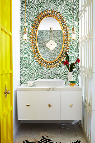 This is an example of an eclectic bathroom in New York with flat-panel cabinets, white cabinets, a freestanding tub, a wall-mount toilet, green walls, porcelain floors, marble benchtops and white floor.