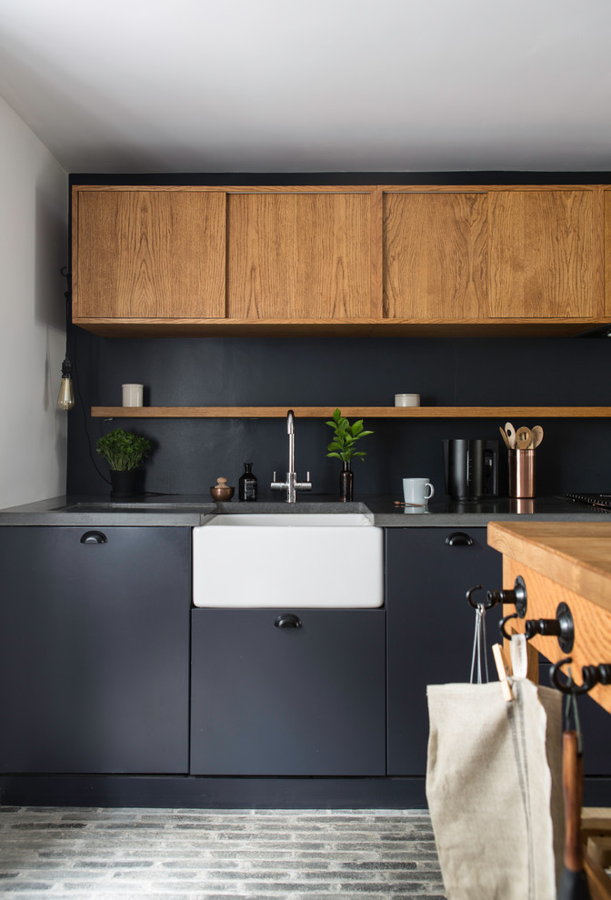 This is an example of a contemporary single-wall eat-in kitchen in Kent with a farmhouse sink, flat-panel cabinets, medium wood cabinets, concrete benchtops, grey splashback, brick floors, with island, grey floor and grey benchtop.