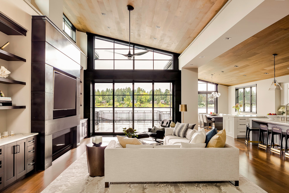 Modelo de sala de estar abierta contemporánea con paredes negras, chimenea lineal, marco de chimenea de metal, pared multimedia y madera