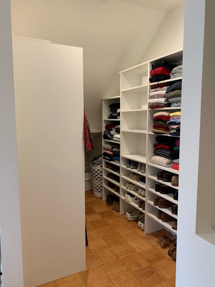 Photo of a large modern walk-in wardrobe in Boston with open cabinets, white cabinets and medium hardwood flooring.