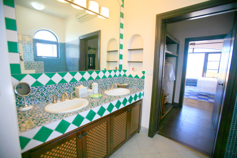 Photo of a large eclectic bathroom in Austin with flat-panel cabinets, dark wood cabinets, green tile, white tile, ceramic tile, beige walls and a drop-in sink.