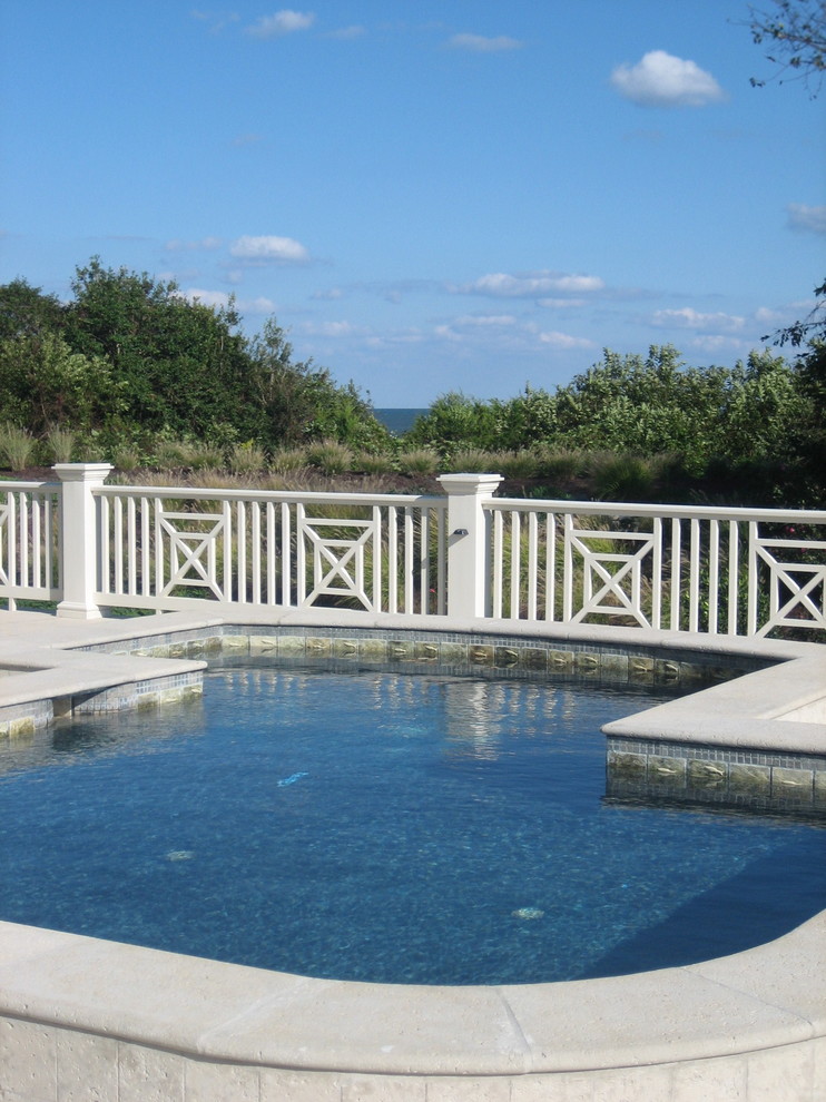 Design ideas for an expansive beach style backyard custom-shaped pool in Jacksonville with a hot tub and natural stone pavers.