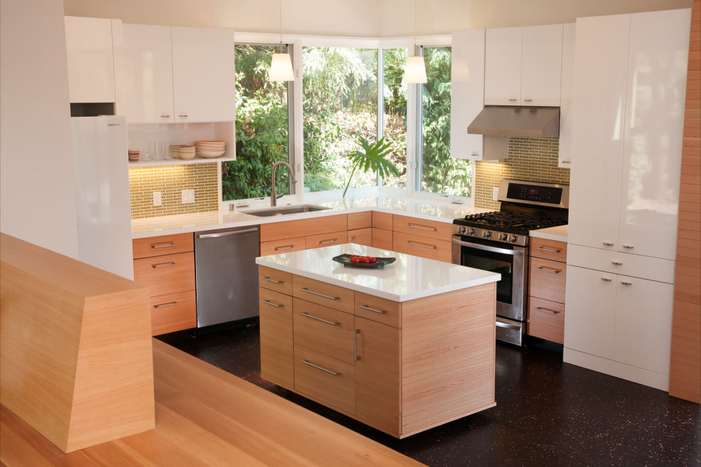 Foto på ett litet funkis vit kök, med en enkel diskho, släta luckor, skåp i ljust trä, bänkskiva i kvarts, stänkskydd i mosaik, rostfria vitvaror, en köksö och svart golv