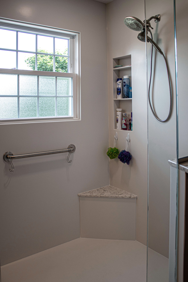Medium sized traditional ensuite bathroom in Cleveland with flat-panel cabinets, grey cabinets, a corner shower, a two-piece toilet, beige walls, laminate floors, a submerged sink, engineered stone worktops, grey floors, a hinged door, a shower bench and double sinks.