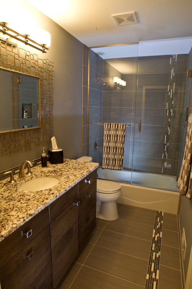 Inspiration for a small transitional gray tile and porcelain tile porcelain tile alcove bathtub remodel in Milwaukee with an undermount sink, flat-panel cabinets, medium tone wood cabinets, granite countertops, a two-piece toilet and gray walls