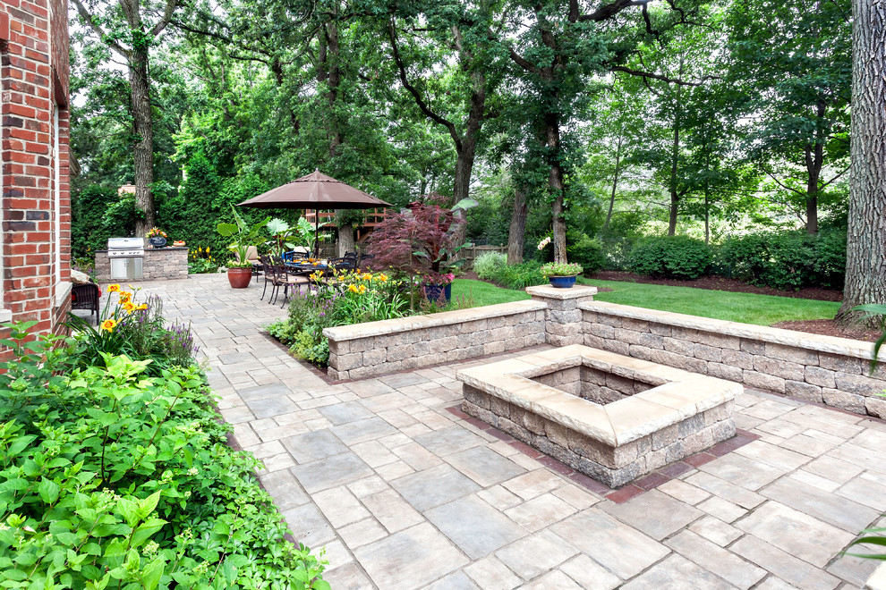 Design ideas for a large traditional backyard patio in Chicago with a fire feature, brick pavers and no cover.