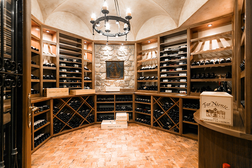 Large traditional wine cellar in New York with brick floors, storage racks and orange floor.