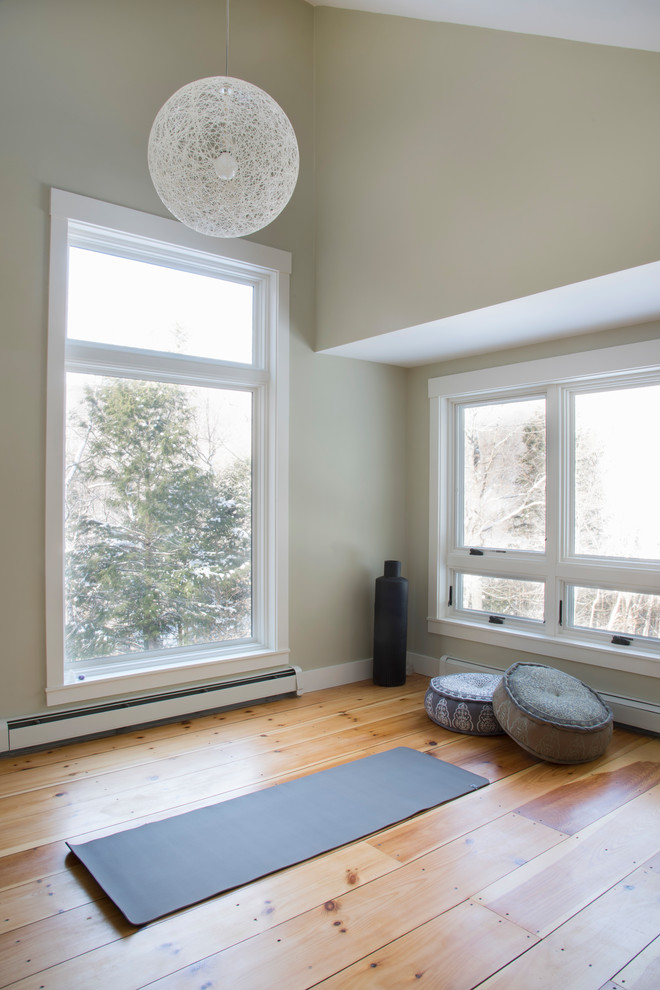 This is an example of a home yoga studio with green walls, light hardwood floors and beige floor.