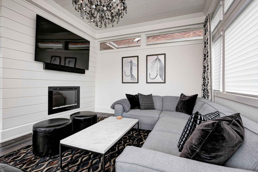 Exemple d'une salle de séjour éclectique de taille moyenne et fermée avec un mur beige, un téléviseur fixé au mur, un plafond en lambris de bois, une cheminée standard, parquet foncé et un sol marron.