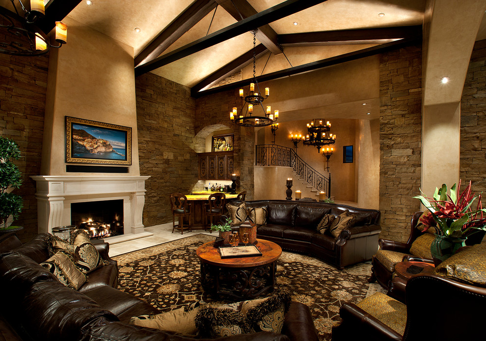 Mediterranean open concept living room in Phoenix with beige walls, a standard fireplace, a stone fireplace surround and a concealed tv.