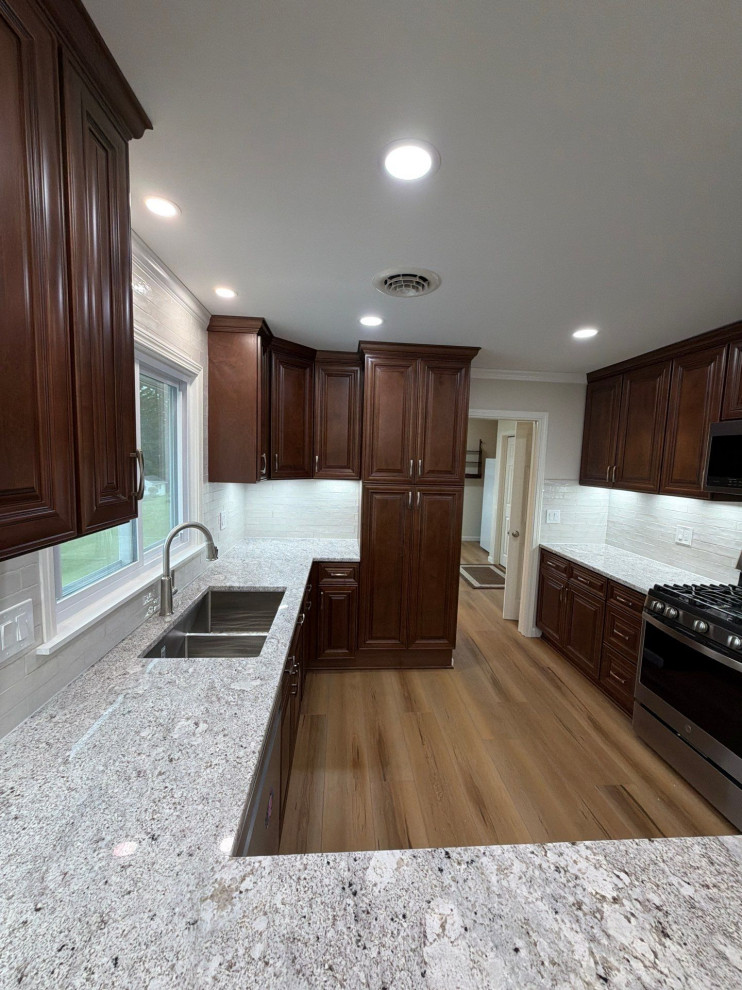 USCD cabinetry accompanied granite countertops, porcelain tile backsplash and Ca