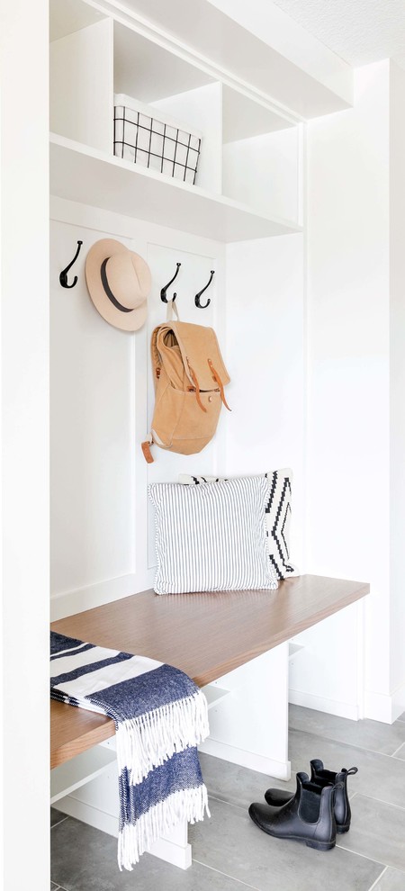 Inspiration for a mid-sized transitional l-shaped porcelain tile and gray floor utility room remodel in Calgary with an undermount sink, shaker cabinets, white cabinets, quartzite countertops, white walls, a side-by-side washer/dryer and white countertops