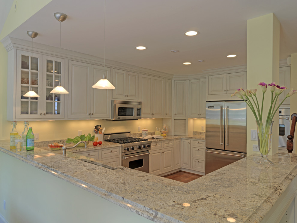 Photo of a traditional u-shaped kitchen in DC Metro with glass-front cabinets, white cabinets and stainless steel appliances.