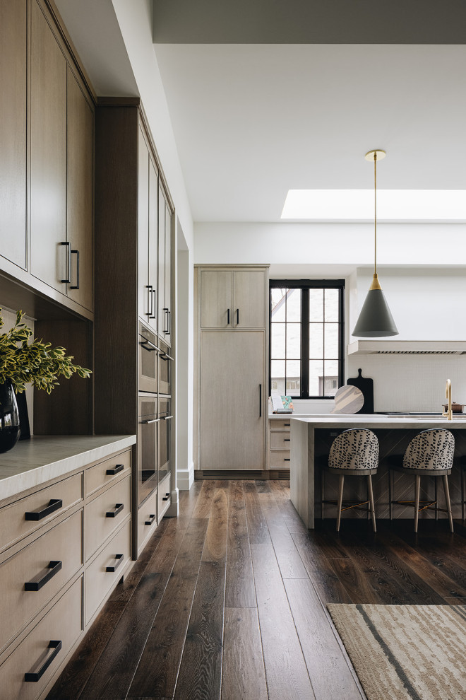 Inspiration for a contemporary eat-in kitchen in Chicago with light wood cabinets, white splashback, with island, brown floor and white benchtop.