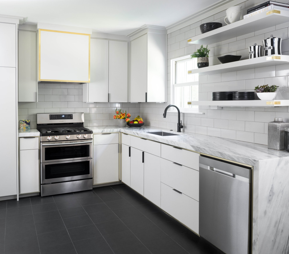 Inspiration for a contemporary l-shaped kitchen in Dallas with an undermount sink, flat-panel cabinets, white cabinets, white splashback, subway tile splashback, stainless steel appliances, black floor and white benchtop.