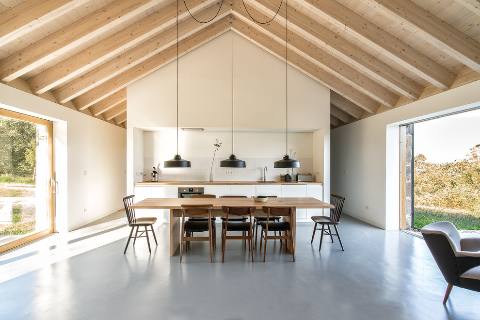 Inspiration for an expansive scandinavian single-wall open plan kitchen in Other with flat-panel cabinets, white cabinets, wood benchtops, white splashback, ceramic splashback, concrete floors, no island and grey floor.