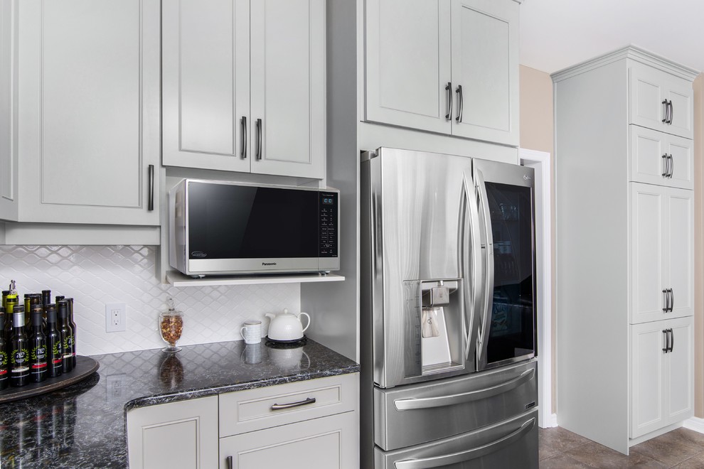 Inspiration for a large transitional u-shaped ceramic tile and beige floor enclosed kitchen remodel with a double-bowl sink, recessed-panel cabinets, gray cabinets, granite countertops, stainless steel appliances, an island and black countertops