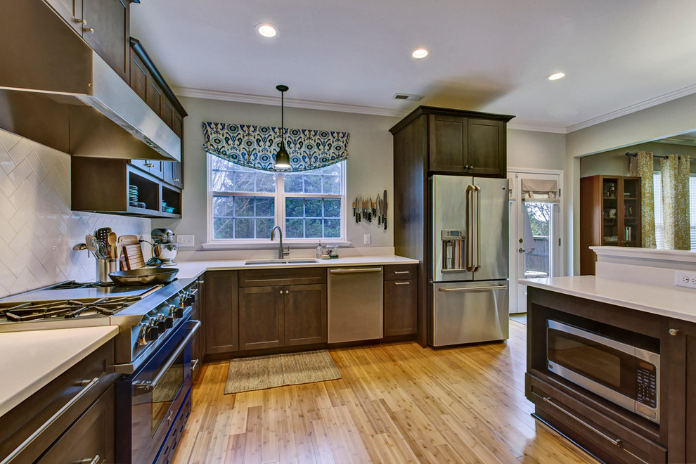 Eat-in kitchen - mid-sized transitional l-shaped bamboo floor eat-in kitchen idea in Raleigh with a double-bowl sink, shaker cabinets, dark wood cabinets, quartz countertops, white backsplash, ceramic backsplash, colored appliances and no island