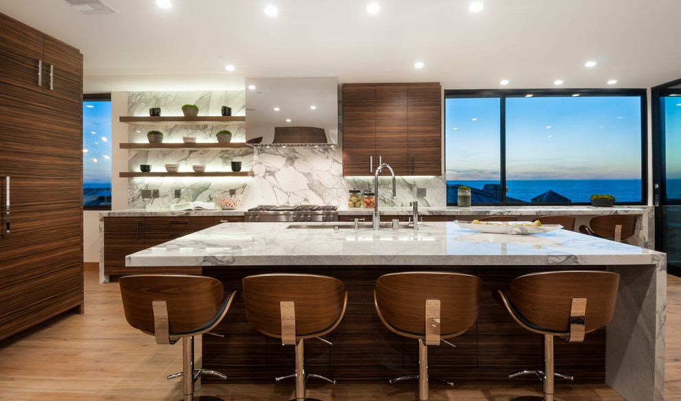 Photo of a contemporary l-shaped open plan kitchen in Los Angeles with an undermount sink, flat-panel cabinets, dark wood cabinets, marble benchtops, white splashback, marble splashback, stainless steel appliances, light hardwood floors, with island and beige floor.