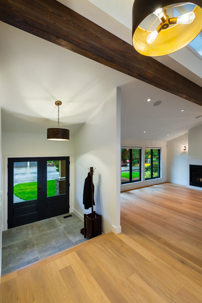 Foyer - mid-sized rustic porcelain tile and gray floor foyer idea in Vancouver with white walls and a black front door