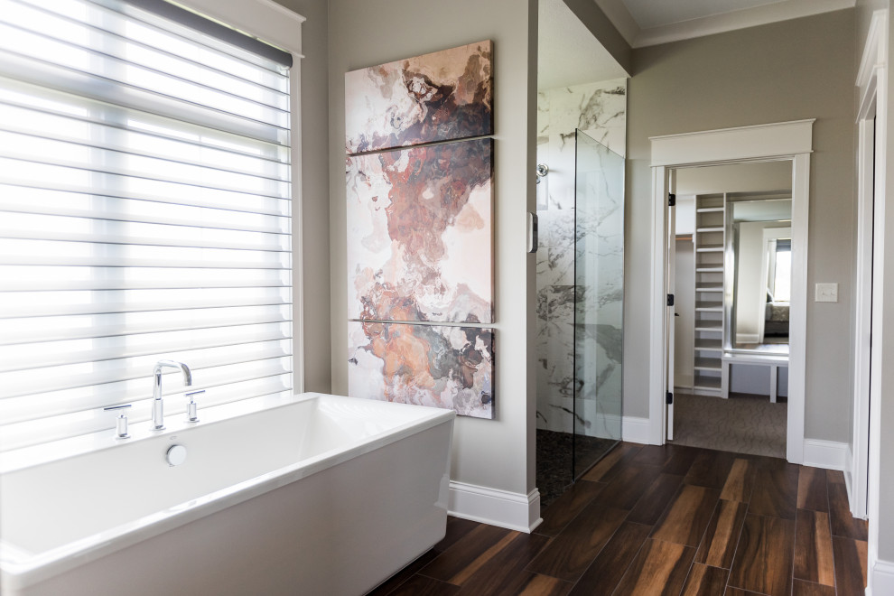 Inspiration for a mid-sized contemporary master wet room bathroom in Indianapolis with shaker cabinets, grey cabinets, a freestanding tub, beige tile, ceramic tile, grey walls, medium hardwood floors, an undermount sink, granite benchtops, a hinged shower door and grey benchtops.
