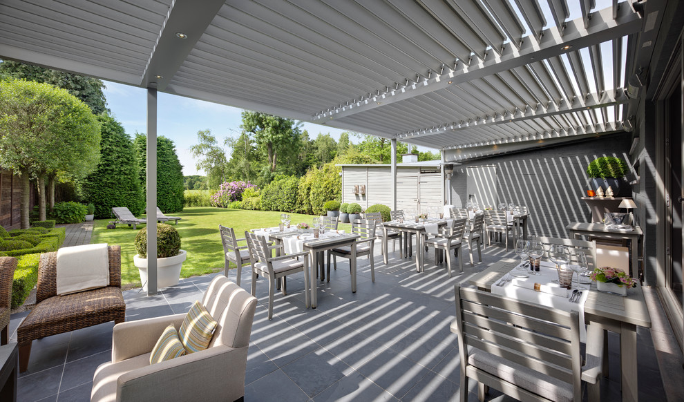 This is an example of a large contemporary backyard patio in Buckinghamshire.