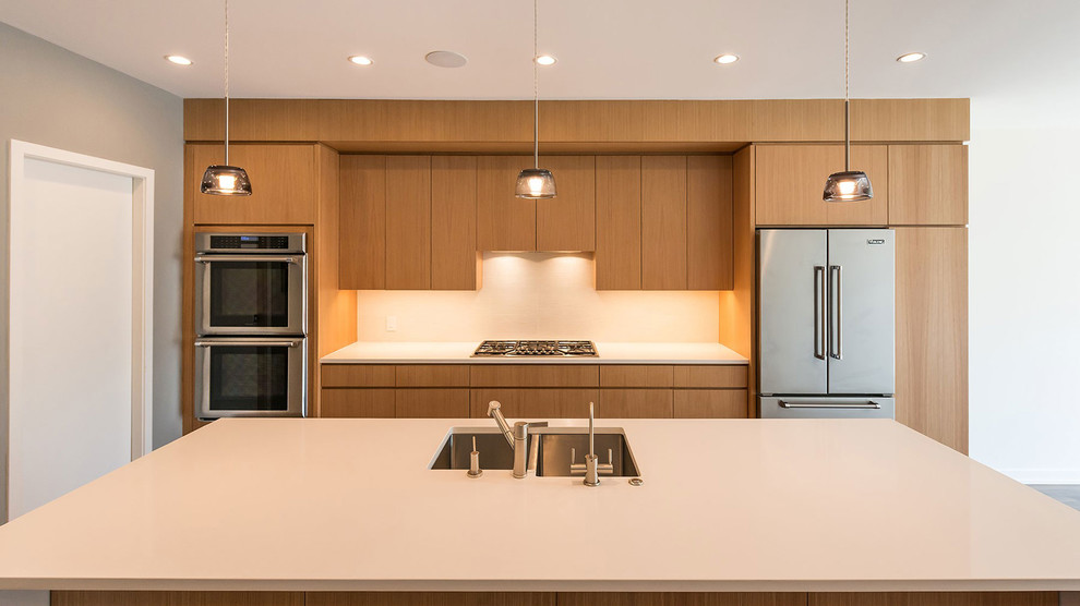Design ideas for a midcentury eat-in kitchen in Chicago with flat-panel cabinets, light wood cabinets, stainless steel appliances and with island.