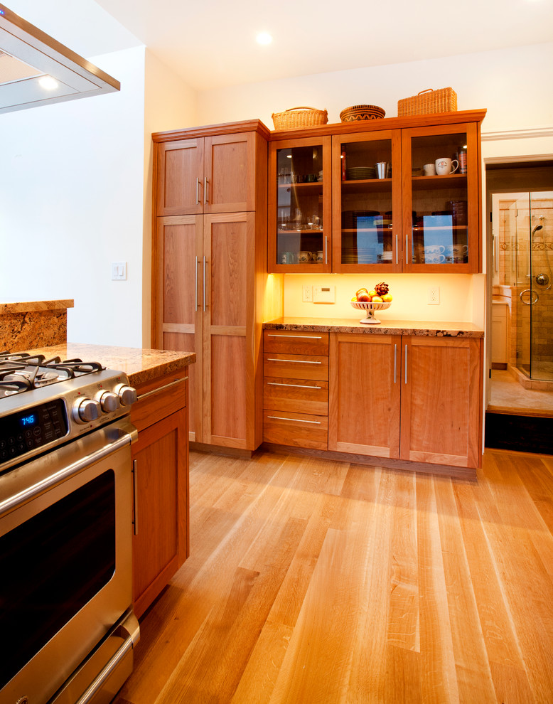 Photo of a small arts and crafts u-shaped separate kitchen in San Francisco with an undermount sink, shaker cabinets, medium wood cabinets, granite benchtops, red splashback, stone slab splashback, stainless steel appliances, a peninsula, light hardwood floors and brown floor.
