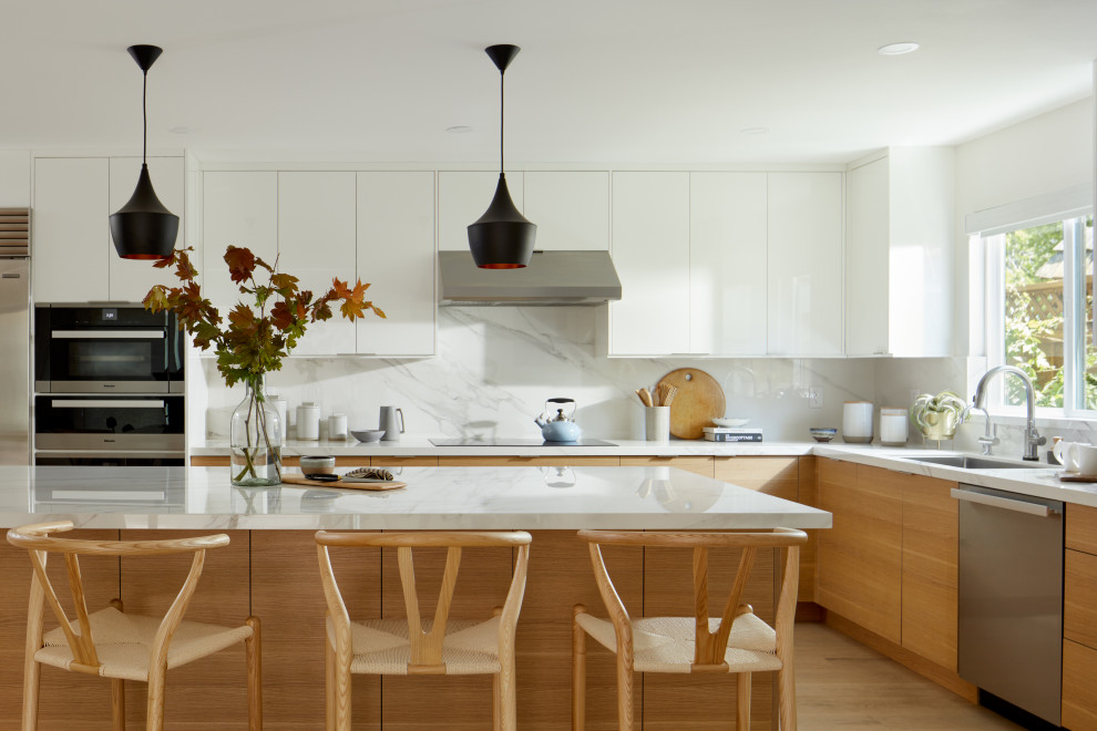 Design ideas for a large midcentury l-shaped eat-in kitchen in San Francisco with an undermount sink, flat-panel cabinets, brown cabinets, quartz benchtops, white splashback, porcelain splashback, stainless steel appliances, light hardwood floors, with island and white benchtop.