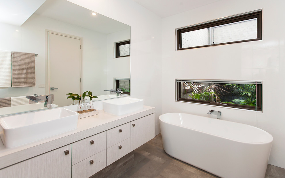 Design ideas for a mid-sized contemporary kids bathroom in Toronto with a vessel sink, flat-panel cabinets, grey cabinets, laminate benchtops, a freestanding tub, an alcove shower, gray tile, porcelain tile, white walls and porcelain floors.