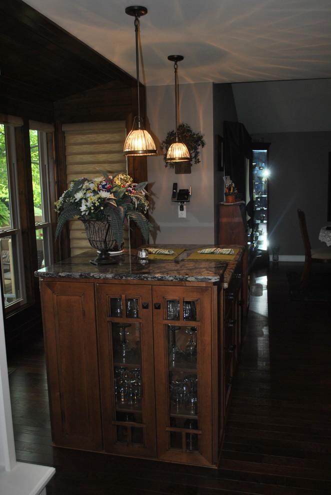 Inspiration for a brown floor kitchen remodel with brown cabinets, beige backsplash, stainless steel appliances, an island and gray countertops