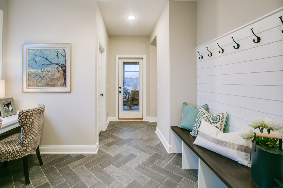 Photo of a mid-sized transitional mudroom in Minneapolis with beige walls, porcelain floors, a single front door, a white front door and grey floor.