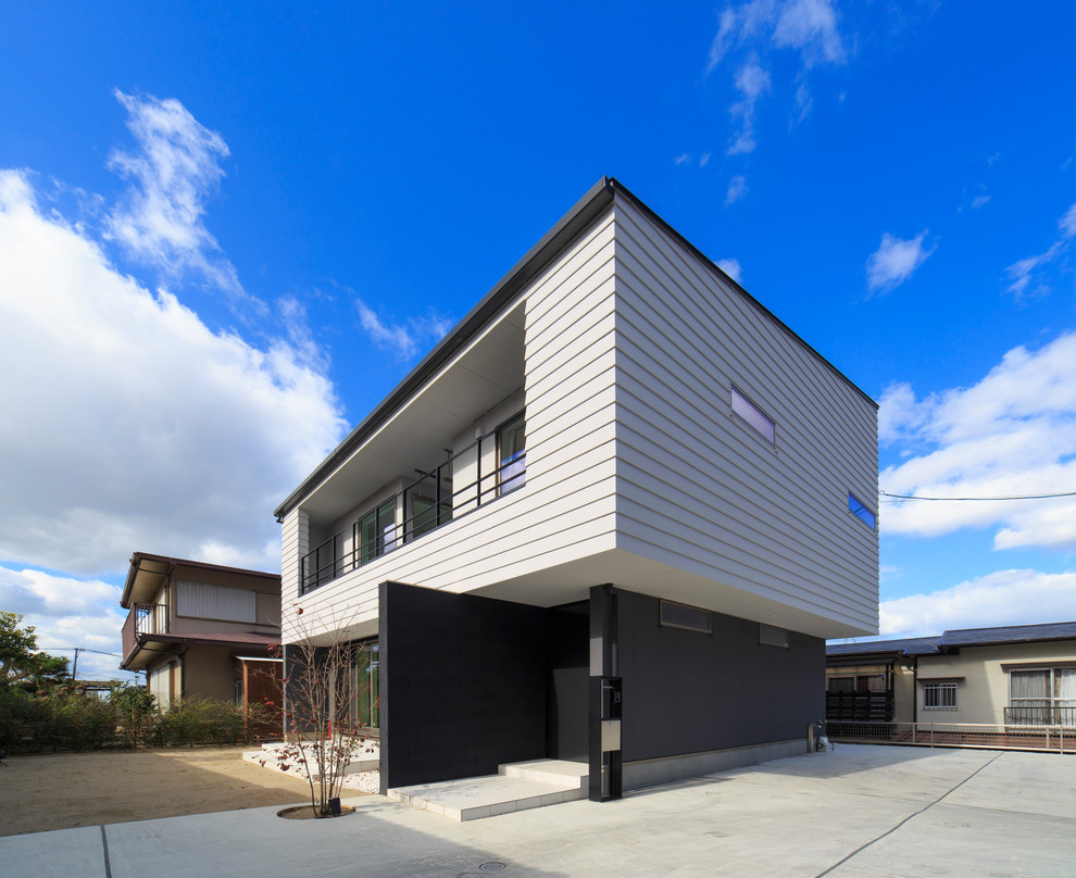 Large contemporary two-storey black house exterior in Fukuoka with mixed siding and a flat roof.