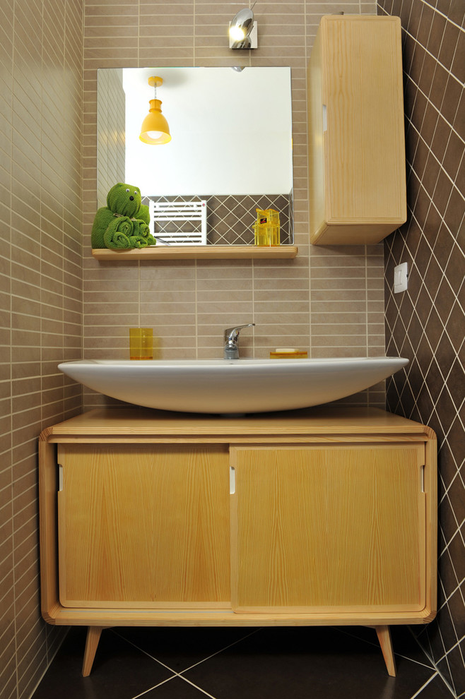 Photo of a small scandinavian powder room in Other with brown tile, brown walls, ceramic floors, flat-panel cabinets, light wood cabinets and a vessel sink.