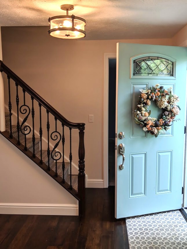 This is an example of a mid-sized traditional foyer in Other with beige walls, dark hardwood floors, a single front door, a blue front door and brown floor.