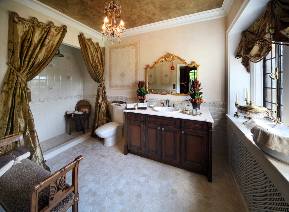 This is an example of a mid-sized traditional master bathroom in New York with dark wood cabinets, an alcove shower, a two-piece toilet, beige tile, gray tile, white tile, beige walls, a drop-in sink and recessed-panel cabinets.