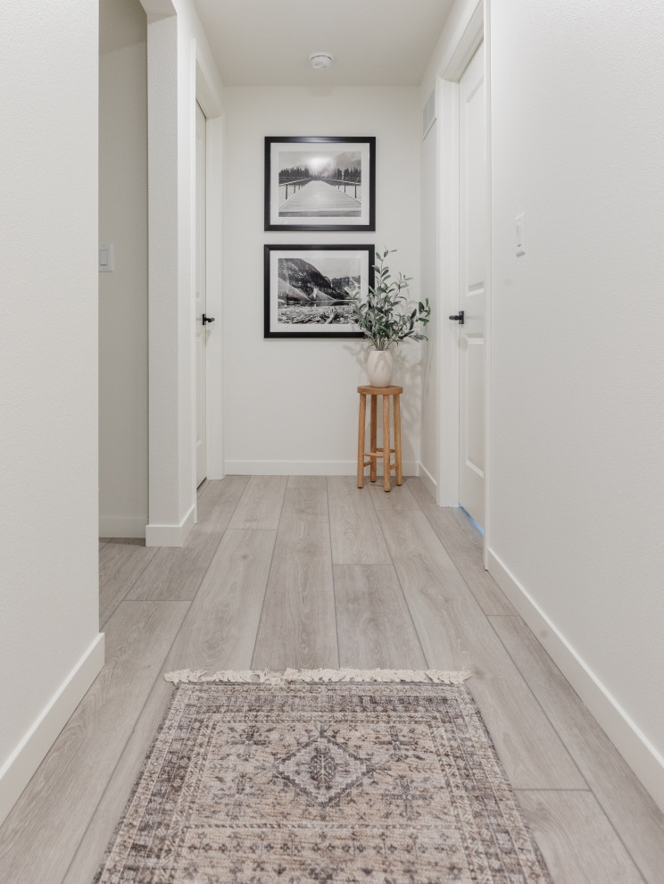Idée de décoration pour un couloir minimaliste de taille moyenne avec un mur blanc, un sol en vinyl, un sol gris et un plafond voûté.