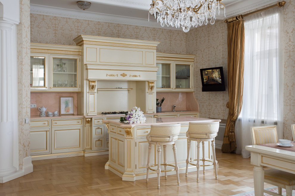 Photo of a traditional galley eat-in kitchen in Saint Petersburg with raised-panel cabinets, white cabinets, pink splashback, stone slab splashback, light hardwood floors, with island, beige floor and pink benchtop.
