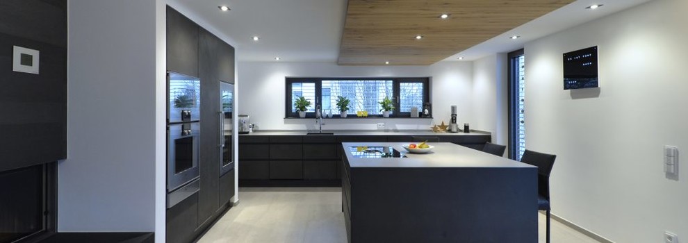 This is an example of a mid-sized contemporary l-shaped open plan kitchen in Other with flat-panel cabinets, grey cabinets, quartz benchtops, stainless steel appliances, ceramic floors, with island and grey floor.