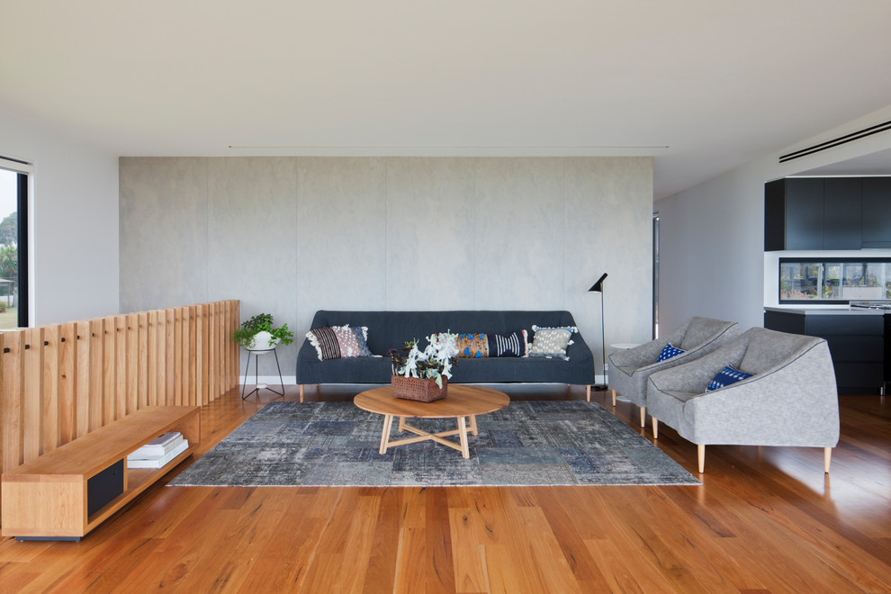 This is an example of a large contemporary open concept living room in Melbourne with white walls, light hardwood floors, a hanging fireplace, a metal fireplace surround and a freestanding tv.