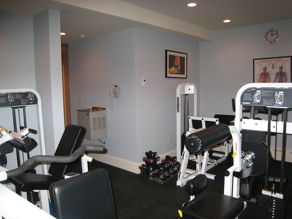 This is an example of a small modern home weight room in New York with blue walls and cork floors.