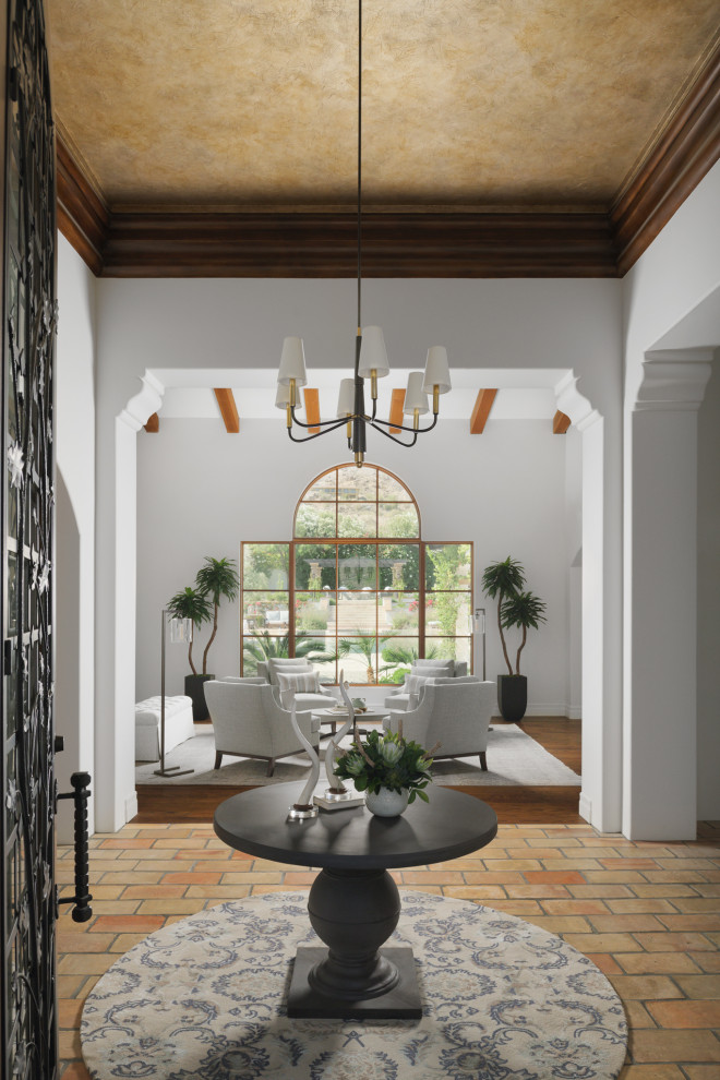 Idee per un ampio ingresso classico con pareti bianche, pavimento in terracotta, una porta singola, una porta nera, pavimento arancione e soffitto a cassettoni