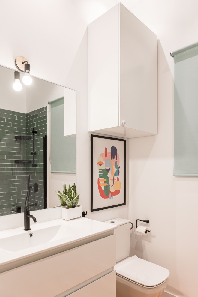 Exempel på ett mellanstort modernt vit vitt en-suite badrum, med släta luckor, vita skåp, en dusch/badkar-kombination, grön kakel, keramikplattor, vita väggar, vinylgolv, ett integrerad handfat, bänkskiva i akrylsten, en toalettstol med separat cisternkåpa och vitt golv