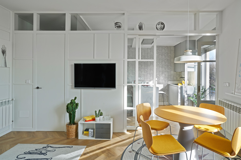Klassisk inredning av ett litet allrum med öppen planlösning, med grå väggar, laminatgolv och en väggmonterad TV